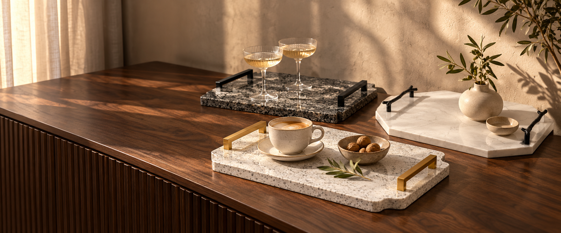 A considered selection of stone trays in a warm, sunlit interior.