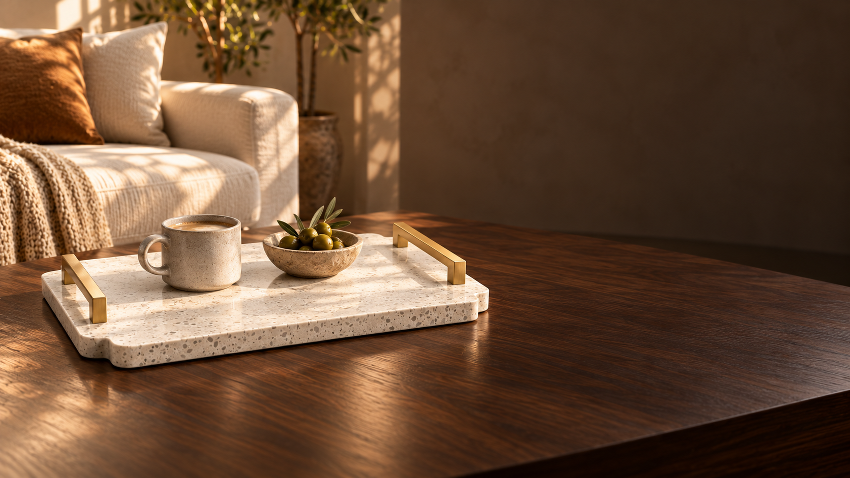 White stone tray with gold handles and coffee on the left side of a warm living room